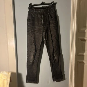 Svarta jeans - Svarta jeans. Högmidjade. Storlek 38. Dessa är mina gamla favoritbyxor så dem är både lagade och lite slitna, dessutom lite solblekta (alla defekter finns med på bild).
