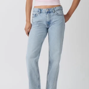 Ljusblå lågmidjade jeans från Ginatricot  - Säljer ett par ljusblå jeans med klassisk lågmidja och raka ben. Jeansen är tillverkade i ett mjukt denimtyg som ger en avslappnad vibe men går även att klä upp. Perfekta att styla med crop tops eller hoodies för en chill look.