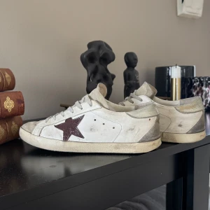 Golden Goose Superstar sneakers vit/grå - Super snygga golden goose! Stjärnan på skon är omgjord till brun då den va rosa innan (därav ett väldigt lågt pris). De är använda, men med omsorg! Box och kvitto tillkommer! Priset kan diskuteras. 