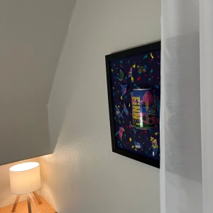 Finn tavla - Bilderna visar en inramad konst med en burk och färgglada motiv på en vägg, samt en lampa. Ingen elektronik att beskriva eller sälja.