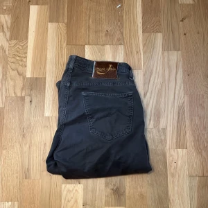  Jacob Cohen - Snygga svarta jeans från Jacob Cohen, modell Type 622.C. Klassisk femficksdesign med silverfärgade nitar och läderpatch bak. Jeansen har en rak passform och är tillverkade i mjuk bomull med lite stretch för extra komfort. Priset kan diskuteras 