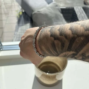 Glittrigt silverarmband med stenar - Säljer ett snyggt armband i silverfärg med glittrande stenar runt om. Armbandet har en klassisk och stilren design som verkligen drar blickarna till sig. Perfekt för dig som vill ha något extra på handleden. Oanvänd 