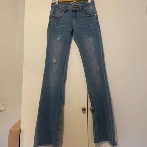 Blå bootcut jeans med slitningar - Snygga jeans, stretchiga o helt oanvända!