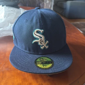 Mörkblå White Sox keps 59FIFTY - Snygg mörkblå 59FIFTY keps från New Era med White Sox-logga framtill och All Star Game 2003 patch på sidan. Kepsen har en rak skärm och broderade detaljer i vitt och turkos. Tillverkad i 100% polyester och ingår i Cooperstown Collection.