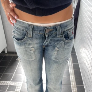 Lågmidjade slitna blå jeans - Så fina lågmidjade bootcut jeans som är jättefina, unika och coola! De har hål och slitningar 🌸  Märke: Terranova 💕 Färg: Blå, ljusblå, mörkblå  Material: Denim   Midjemått: 40 cm Innerbenslängd: 85 cm  Vid frågor är det bara att höra av sig! 😊 Bundle = rabatt  💕