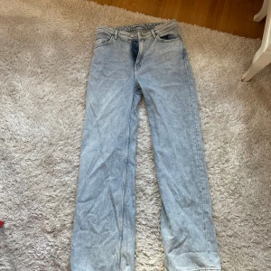 Ljusblå raka jeans från Monki - Säljer ett par ljusblå jeans från Monki med klassisk femficksdesign och raka ben. Jeansen har normal midja och är tillverkade i ett slitstarkt bomullsjeansmaterial. Perfekta för en avslappnad och trendig look.