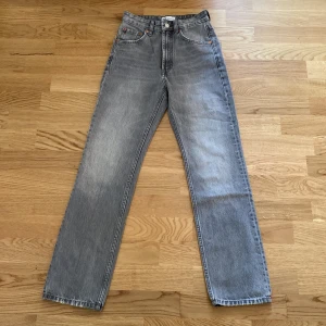 Grå raka jeans från Zara - Snygga grå jeans från Zara med raka ben och klassisk femficksdesign. Jeansen har hög midja och är tillverkade i ett slitstarkt bomullsjeanstyg. Perfekta för en avslappnad och trendig look.