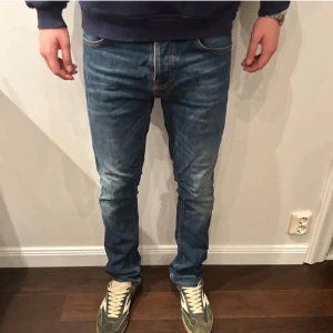 Nudie jeans Grim Tim - Säljer dessa sjukt snygga Nudie jeans i modellen Grim Tim. Bra skick utan hål fläckar eller annat.Finns en liten defekt och de är nudie märket bak på byxorna men det är inget som syns vid användning.                                                       Storlek 33/34 personen på bilden är 180cm