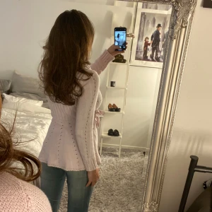 Ljusrosa omlottkofta från Bondelid - Supersöt ljusrosa stickad kofta från Bondelid i omlottmodell med knyt i sidan. Koftan har långa ärmar, bred krage och fina hålstickade detaljer som ger en perfekt höstig och vinter känsla. 