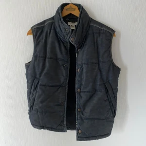 Vintage 2000s Archive Diesel Dragon Dark Denim Puffer Vest - Unik vintage Diesel-vest från 2000-talet! Mörk denim med drakdetaljer, puffad design och klassisk Diesel-archiv-look. Mycket fint skick – perfekt för streetwear och samlare. Size L, men ganska liten i storleken så passar även S/M
