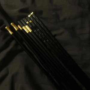 Lyxiga ätpinnar  - LIORA STICKS UF💗Bilderna visar ett set med eleganta ätpinnar i svart och guld, med dekorativa detaljer på toppen. Vi har även en extra hjälp del som gör det mycket enklare att äta med pinnarna. Priserna är följande enbart hjälp del 25kr, enbart sushipinnar 49kr och hela settet för endast 59kr🌸Pinnarna finns i svart och elegant mörkgrön!☺️