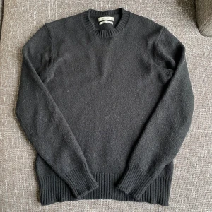 Svart merinoullströja från Mango - Klassisk svart tröja från Mango Man i extra fin merinoull. Tröjan har rund halsringning, ribbade muddar och är långärmad. Perfekt för lager-på-lager och enkel att matcha med olika outfits. Liten i storleken