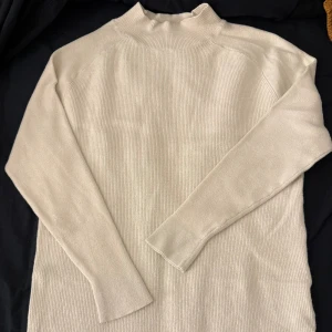 Stickad tröja  - Stickad tröja med slits på kanterna, lite längre modell 