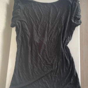 Svart enkel linnetopp från Vero Moda - Säljer en svart linnetopp från Vero Moda i storlek L. Toppen har en klassisk rund halsringning och är ärmlös, perfekt för varma dagar. Materialet är mjukt och lätt bomull, vilket gör den skön att bära. Passformen är normal och toppen är stilren utan detaljer.