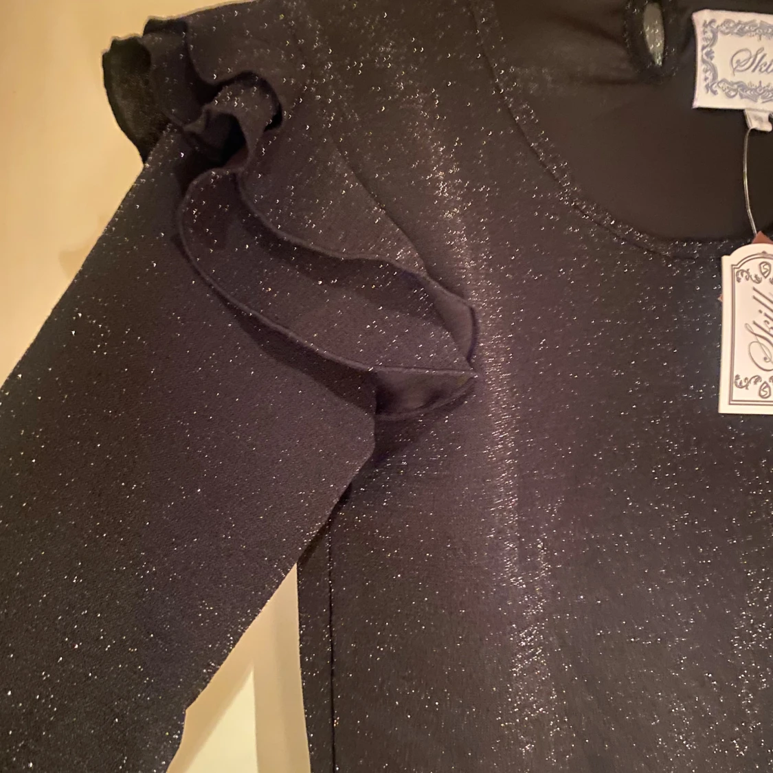 Svart glittrig topp med volang från Skill - 2