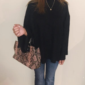 Nuna lie väska - Snygg handväska i rosa/bruna toner med svarta detaljer. Ger direkt en uppklädd look utan att bli för mycket, passar både till vardag och fest. Använd gå gånger och i toppskick. Rymlig men smidig, får plats med allt du behöver. Perfekt för att lyfta en simpel outfit.