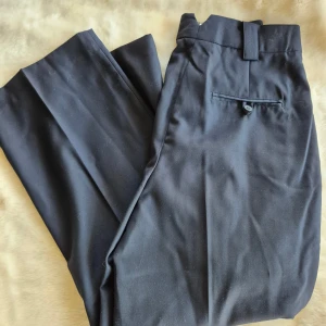 Kostymbyxor i ullmix  -  nya. Jag upplever att dem är små i storleken då dem inte passar mig som vanligtvis har storlek 38. Mått i midjan är 75-76cm (lite svårt att mäta exakt) längden är ca 95cm. Säljer även ett par gråa i samma modell och storlek. Katt finns i hemmet