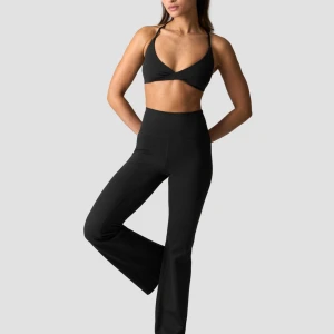 Svarta bootcut träningsbyxor från ICANIWILL - Snygga svarta bootcut träningsbyxor från ICANIWILL med hög midja och stretchigt material. Perfekta för gymmet eller yoga, med diskret logga bak på linningen. Byxorna har en tight passform upptill och utsvängda ben för en modern look.