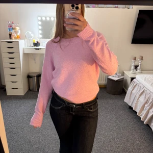 Ljusrosa stickad tröja - Supermysig ljusrosa stickad tröja med rund halsringning och långa ärmar. Tröjan har en relaxed fit och ribbade muddar vid ärmslut och nederkant. Perfekt att slänga på sig när man vill vara både bekväm och snygg.