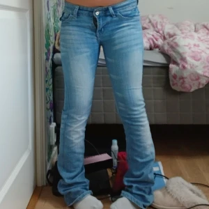 Ljusblå lågmidjade bootcut jeans - Säljer ett par ljusblå jeans från Riever med snyggt broderade bakfickor och klassisk femficksmodell. Jeansen har låg midja och bootcut passform. Jag är 152 för referens och dem är lång på mig vilket ni ser på sista bilden. Säljer då dem är för små för mig. 