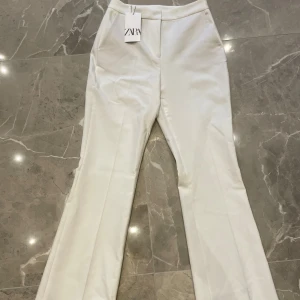 Vita kostymbyxor från Zara - Snygga vita flare kostymbyxor från Zara i storlek S. De är helt nya med prislapp! Pris kan diskuteras vid snabb affär 💕
