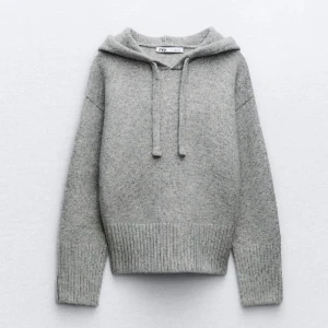 Grå stickad hoodie från Zara - Mysig grå stickad hoodie från Zara med huva och snörning. Tröjan har ribbade muddar vid ärmslut och nederkant, samt en relaxed passform som är perfekt för chill dagar. Enkel och stilren design som funkar till jeans eller mjukisbyxor i storlek S i super bra skick