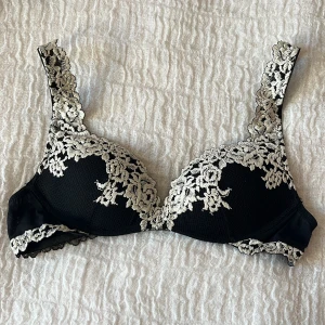 Intimissimi bh - Supersnygg svart Intimissimi bh med vit blommig spetsbrodyr längs kupor och axelband. Endast använt typ 5 gånger.