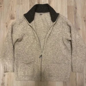 Beige/grå grå stickad cardigan - Riktigt snygg beige/grå stickad cardigan. Modellen är 180cm, 74kg. Priset kan såklart diskuteras!