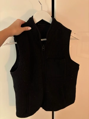 Svart Teddyväst från Only - Svart fleeceväst från ONLY med dragkedja framtill och en bröstficka. Perfekt till vintern, i strl M (passar mig med xs-m)