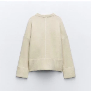 Beige stickad tröja från Zara - Beige stickad tröja från Zara med breda ribbade muddar och markerad söm mitt fram och bak. Lite nopprig men ingenting man lägger märke till😊 