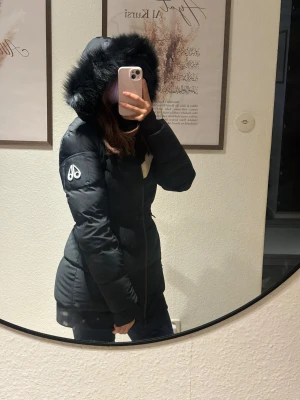 Moose Knuckles Limited Edition  - Svart dunjacka från Moose Knuckles med en vit detalj över bröstet och loggan på vänster ärm. Jackan har en avtagbar huva med svart päls. Den har även en dragkedja framtill och fickor med dragkedja på sidorna.  Jackan är använd max 3 gånger med andra ord jackan är i princip nyskick, inga skador eller märken alls! Köptes från thernlunds i Stockholm för 13 799kr. Kvitto finns. Storlek: XS
