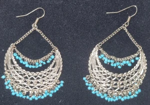 Silvriga örhängen med turkosa pärlor - Unika silvriga örhängen med hängande kedjor och detaljerade mönster. Dekorerade med små turkosa pärlor som ger en färgklick och bohemisk känsla. Perfekt för dig som vill sticka ut med snygga accessoarer.