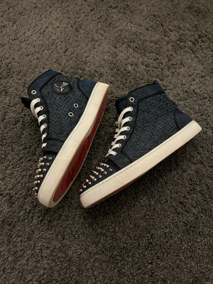 Denim Christian Louboutin skor  - Extremt unika och sällsynta höga Christian Louboutin sneakers i flätat denim material. Storlek 42. Väldigt bekväma och unika samt extremt lätta att stylea. Dessa går inte att hitta någonstans. Väldigt bra skick. 