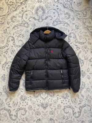 Polo Ralph Lauren dunjacka  - Säljer en Ralph lauren dunjacka i nyskick. Storlek M. Aldrig använd. Snygg och varm för vintern. Kan frakta eller mötas upp i Stockholm. Postar inom 24 timmar. Skriv gärna för fler frågor eller bilder.