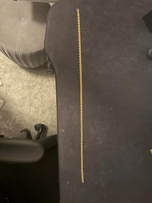 Guldfärgat halsband i tvinnad kedja - Säljer ett snyggt halsband i guldfärg med tvinnad kedja och karbinlås. Märkt med 925 vilket betyder att det är i silver med guldplätering. Kedjan är chunky och ger en riktigt fet look runt halsen.