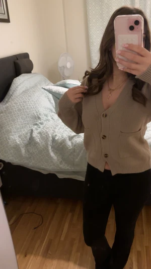 Beige kofta med knappar och fickor - Säljer en beige kofta med s knappar och två praktiska fickor framtill. Koftan är stickad med ribbade muddar och har inte används.❤️ pris går att diskuteras!