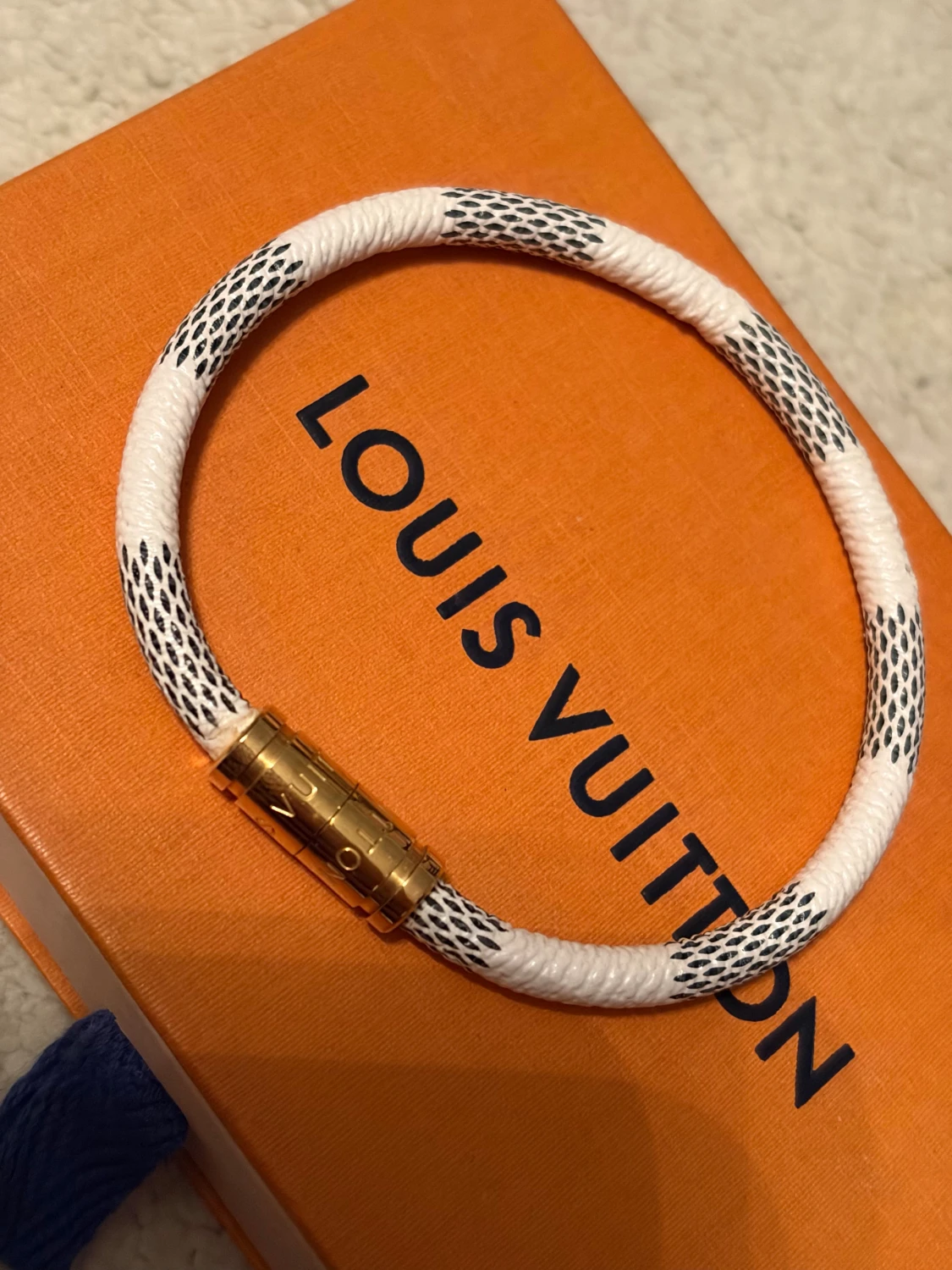 vitt armband med guldspänne