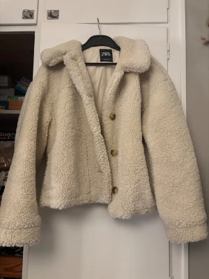 Beige teddyjacka från Zara - Säljer en fluffig och mysig teddyjacka från Zara i beige färg. Säljer då den inte kommer till användning längre, den är i väldigt fint skick änvänd några fåtal gånger, pris går att diskuter och skrev om man vill ha fler bilder