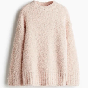 Ljusrosa fluffig stickad tröja - Supermysig ljusrosa stickad tröja i mjuk, fluffig kvalitet. Tröjan är långärmad med lös passform och har rund, ribbad halsringning och nedhasad axel. Ribbstickad kant vid ärmslut och i nederkant. Helt ny, prislapp sitter kvar. 