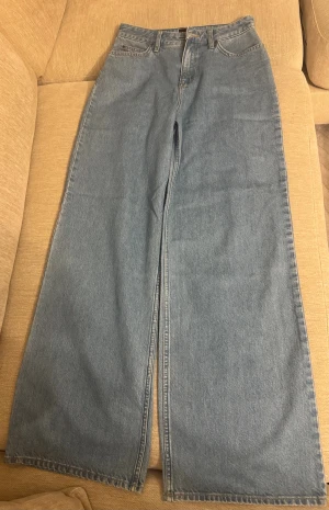 Wide jeans från Lee i ljusblå denim - Säljer ett par ljusblå jeans från Lee med klassisk femficksdesign och dragkedja. Modellen har hög midja och riktigt breda ben för en cool och avslappnad vibe. Materialet är 100% bomull och jeansen har en stilren look utan slitningar eller detaljer.