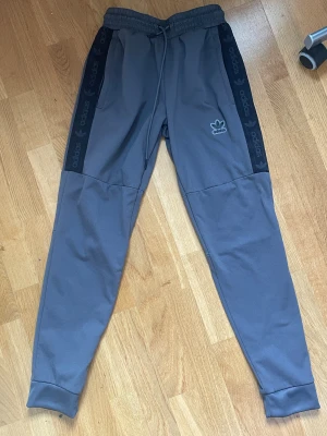 Grå Adidas mjukisbyxor med logga - Gråa mjukis från adidas. Använt skick med knottror. Storlek S. Herr. 