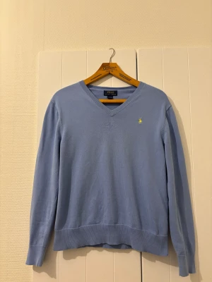 V-ringad Polo Ralph Lauren tröja - Ljusblå v-ringad Polo Ralph Lauren i väldigt fint skick och med 100% bomull, den ikoniska loggan i gul⭐️