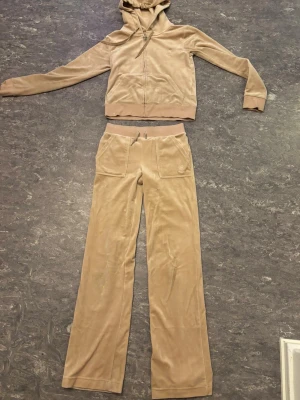 Rosa juicy couture  - Säljer ett par rosa juicy byxor . Byxorna har stora fickor framtill och är gjorda i mjukt velourmaterial som känns skönt mot huden. Perfekt för chill dagar och har en snygg, avslappnad look. Byxorna är i storlek XXS och hoodien i XS.