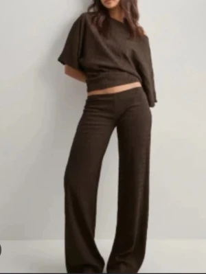 Bruna vida byxor i stickad material - Detta bruna sett från Nelly som knappt är använt 