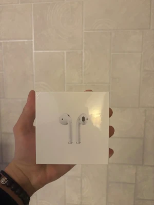 Apple AirPods - Helt nya Apple AirPods med trådlöst laddningsetui, fortfarande i obruten förpackning. Kompatibla med iOS-enheter, 