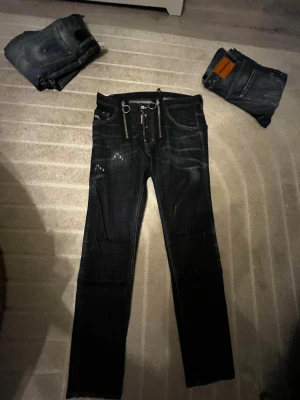 DSQUEARED2 jeans - Ett par häftiga DSQUARED2 jeans i strl 46 nu för salu! En häftig design med inte för många färg fläckar gör dessa jeans extremt unika. Använd 1 gång och inte mer, detta par var för stort för mig.