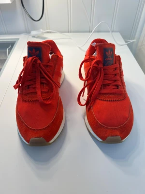 Adidas röda skor strl 36 - Supersnygga röda adidas skor som aldrig fått komma till användning. Säljer av kläder pga av flytt utomlands, finns på andra sidor också. Först till kvarn, bud prioriteras ej. 