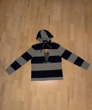 Polo Ralph lauren hoodie randig björn - Sjukt snygg hoodie från polo Ralph lauren. Nypris ligger runt 1500 mitt pris är 799, kan diskutera pris dma bara. Inga defekter kan visa close up bilder vid funderingar. Säljer på grund av att den har blivit för liten för mig. Den är använd ett fåtal gånger och är i otroligt bra skick. Extremt bra kvalité och jätte skön att bära. 