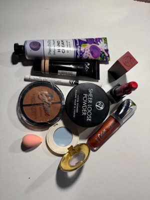 Sminkpaket med puder, bronzer & läppstift - Paket med W7 Sheer Loose Powder i nyansen Biscuit, Glam of Sweden Bronzing Powder Shine & Matte, rött W7 läppstift, kopparfärgat Big läppglans, vit eyelinerpenna, blå ögonskugga (HM)i rund dosa och en liten rosa beautyblender. Perfekt för dig som vill testa olika sminkprodukter! Varorna är nya och har inte används mycket men tyvärr två av de ser lite gammal ut jag lägger 150 kr men ordinarie pris om man köpar de så blir de 240kr men priset kan fixas också genom kontakt 🥰