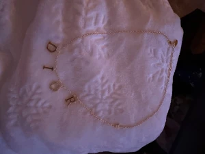 Dior halsband i guld med bokstäver - Snyggt och stilrent halsband från Dior i guldfärgad metall med hängen som bildar ordet DIOR. O:et är dekorerat med små glittrande stenar för extra bling. Perfekt accessoar för att lyfta vilken outfit som helst.